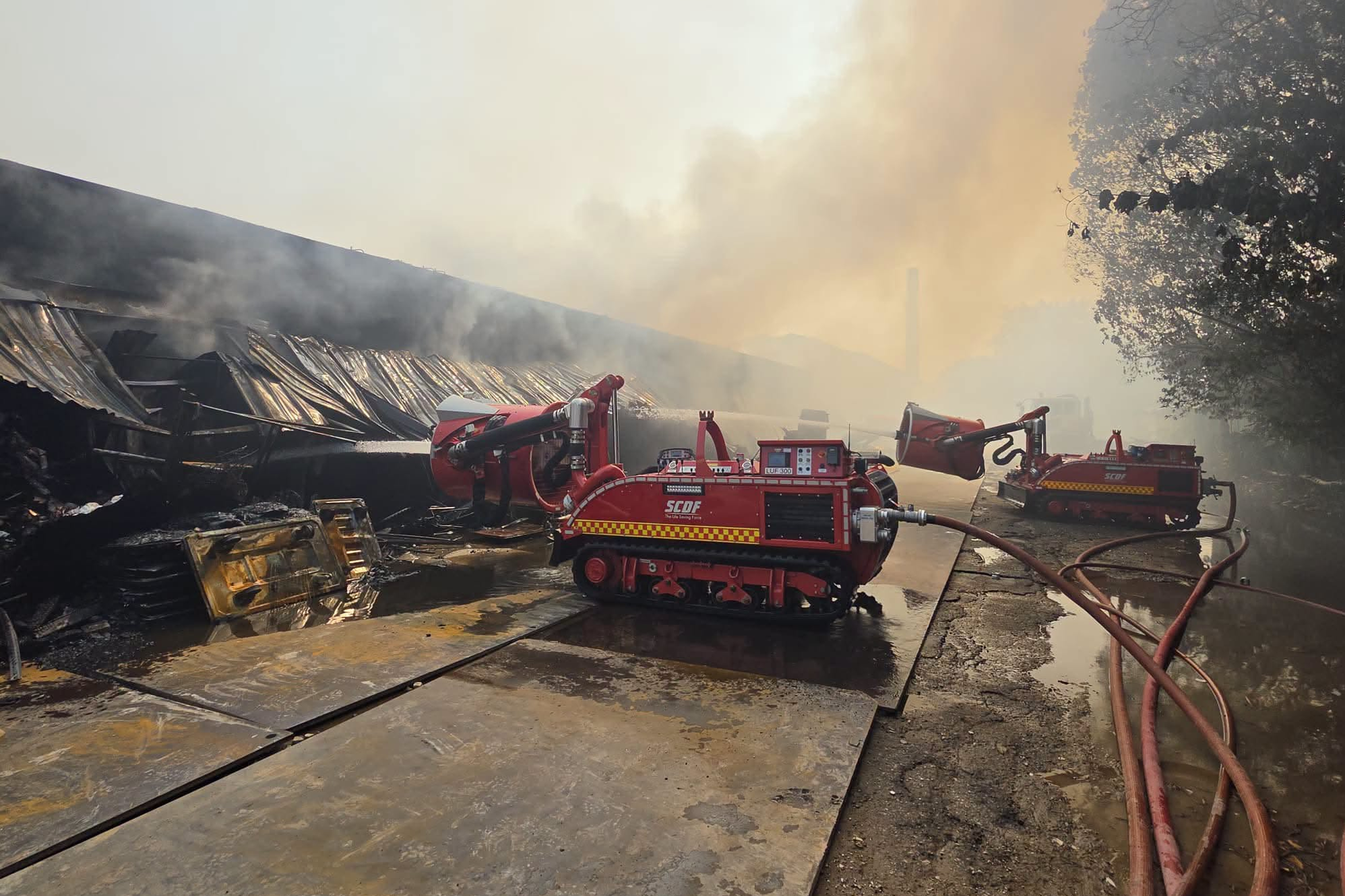 SCDF's unmanned firefighting machines conducting dampening down at the warehouse.