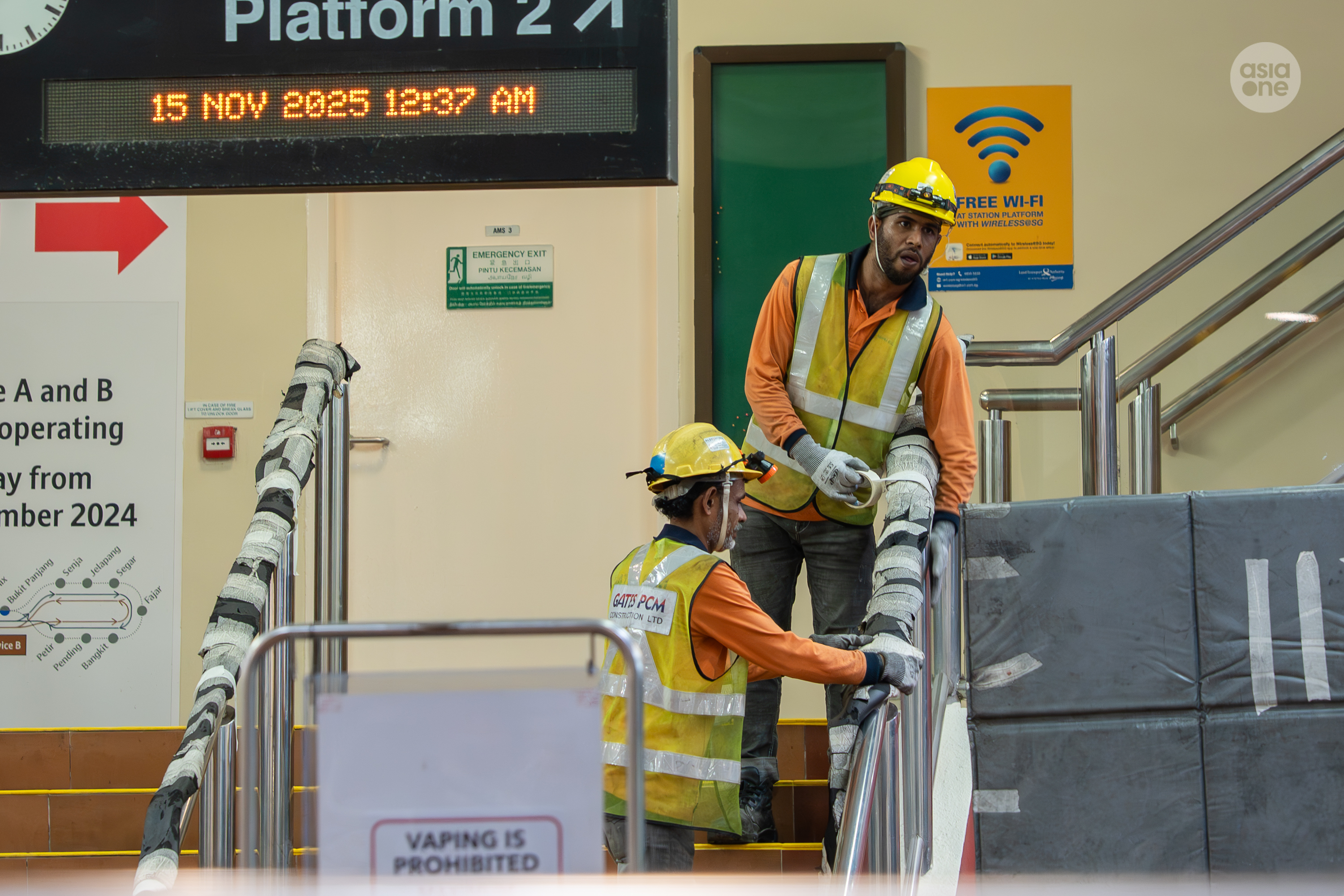 Workers putting up protective cladding at Bangkit LRT station before moving the power rail segments to the platform.