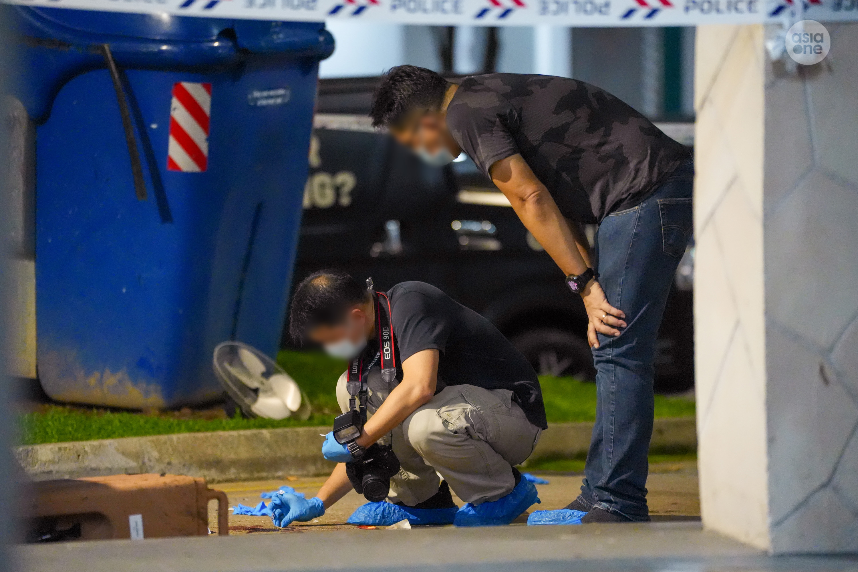 Crime scene specialists documenting the scene at the location where the man is believe to have landed, after falling from the 18th floor.