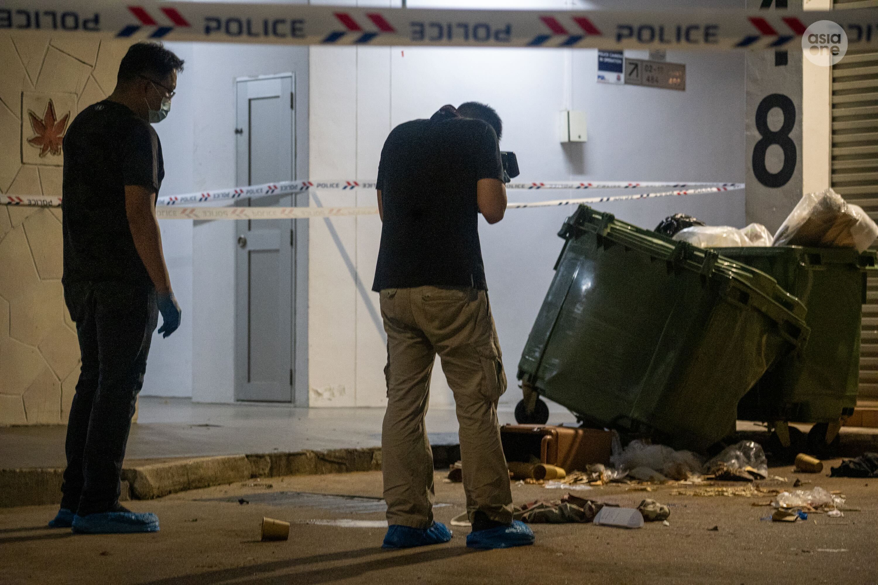 Crime scene specialists documenting the scene at where the 22-year-old man purportedly landed at after falling from the 18th floor.