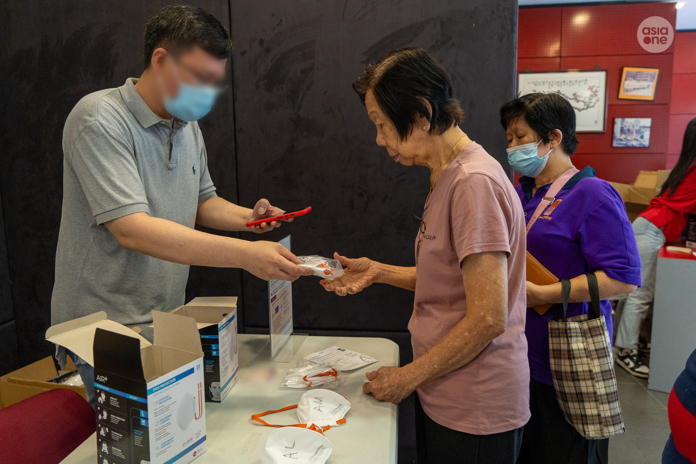 A staff from Kallang Community Club assisting a resident with her N95 masks redemption on Thursday (Oct 15) afternoon.