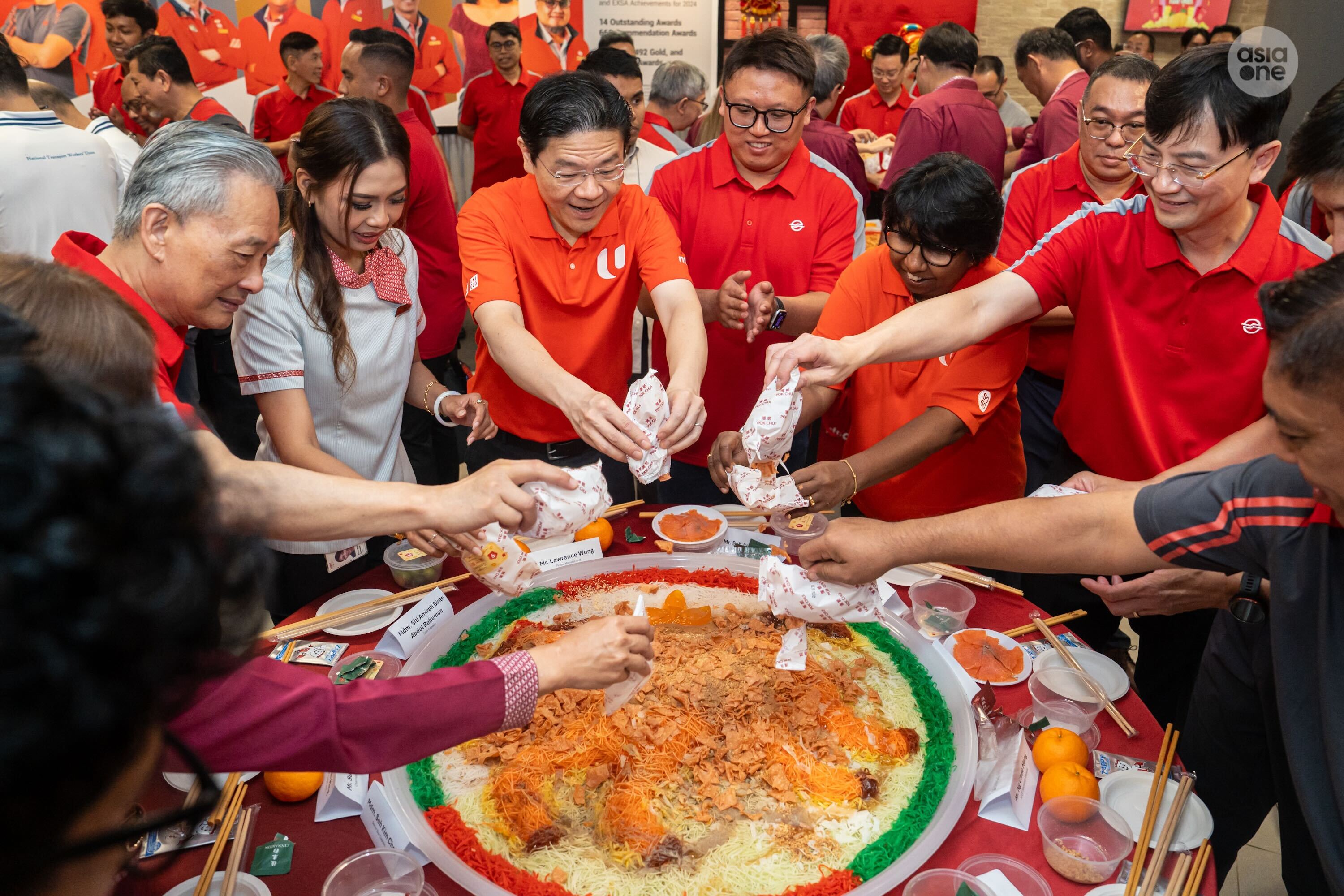 PM Wong tossing yusheng with SMRT and labour movement staff members and leaders.