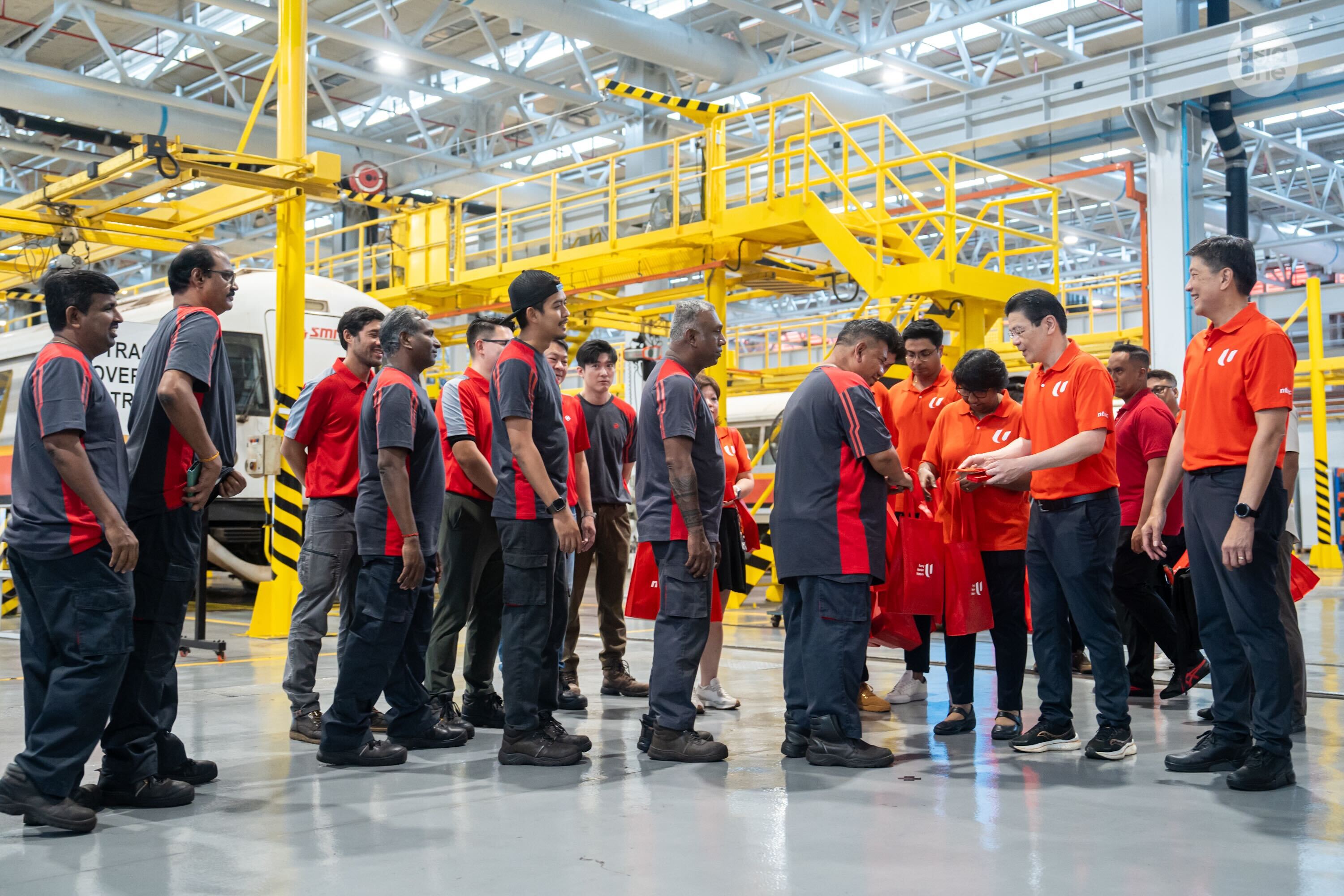 PM Wong and labour movement leaders presenting SMRT workers with a gift bag for the Chinese New Year.