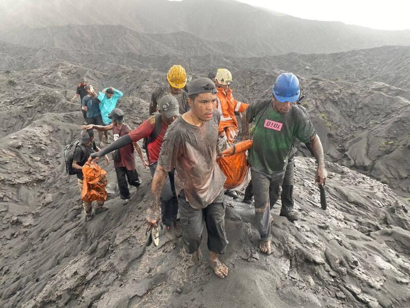 Indonesian rescuers recovering the bodies of the two Singaporeans who died on Mount Dukono after it erupted on May 8.