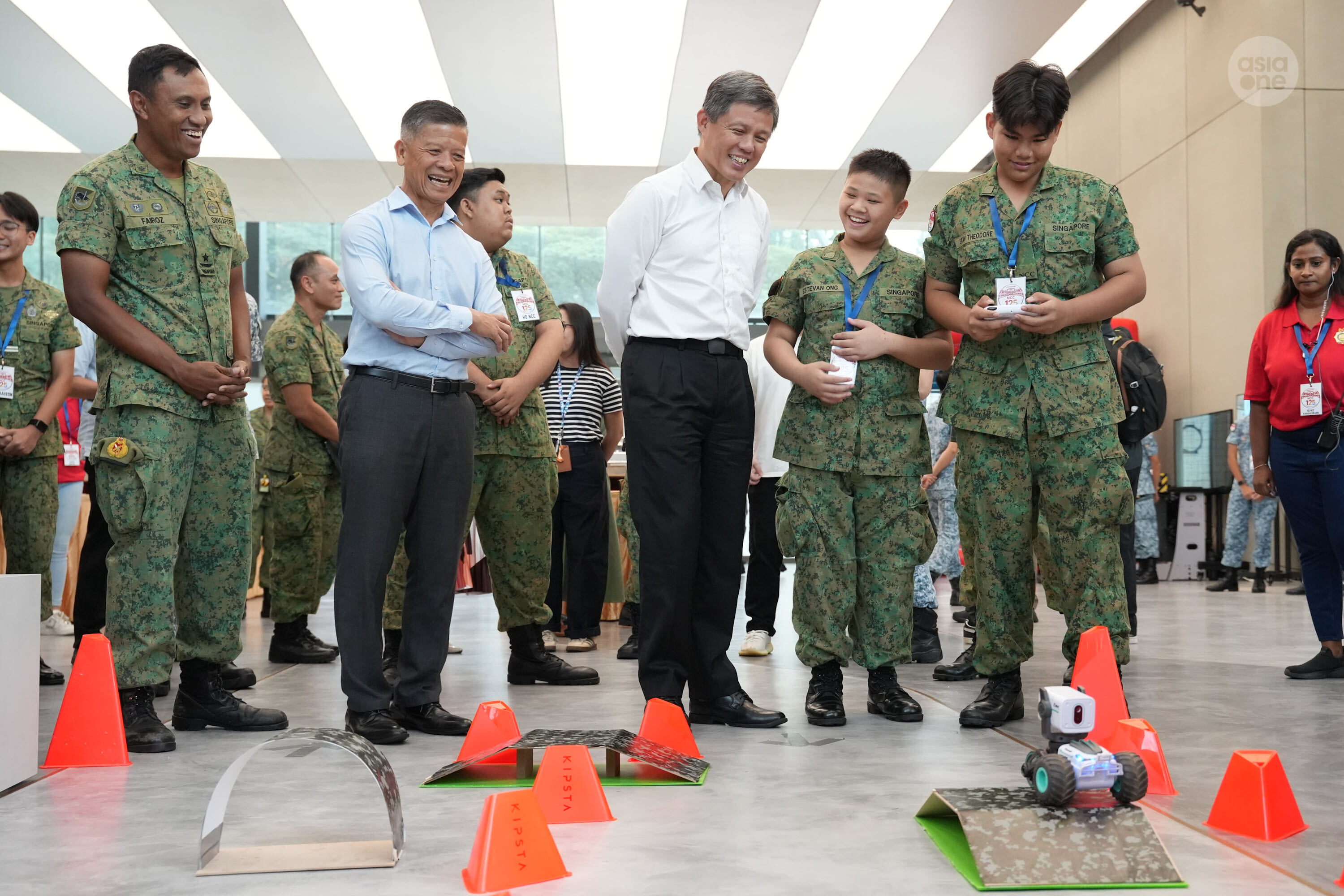 Defence Minister Chan Chun Sing interacting with NCC cadets at a robotics display booth. Hands-on exposure to robotics, drones, and cyber skills are part of the common core training enhanced introduced into the NCC curriculum under the NCC 2030 roadmap.