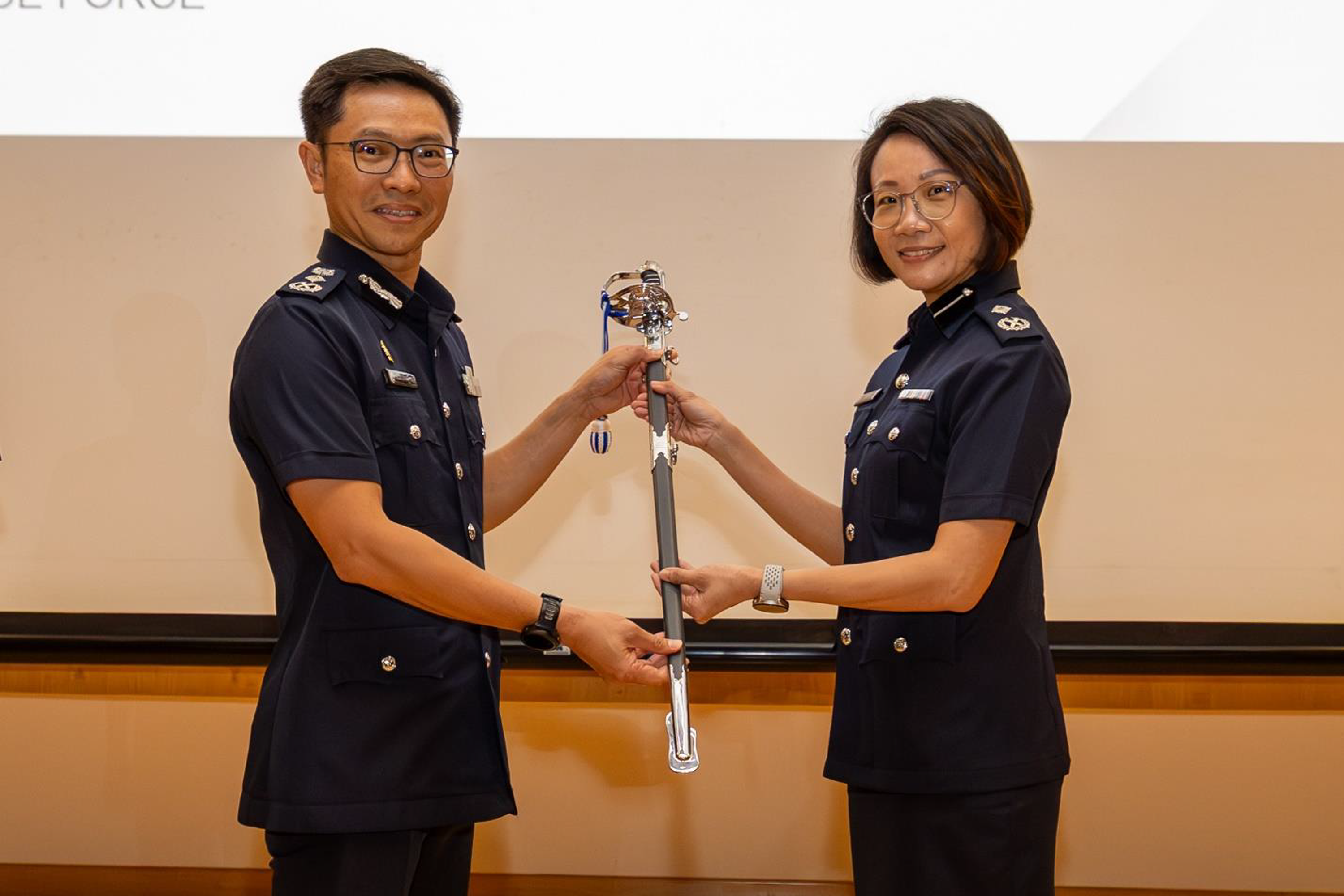 AC Tay Wee Li taking over the command sword from Commissioner of Police (CP) How Kwang Hwee during the change of command ceremony on Monday (June 15).