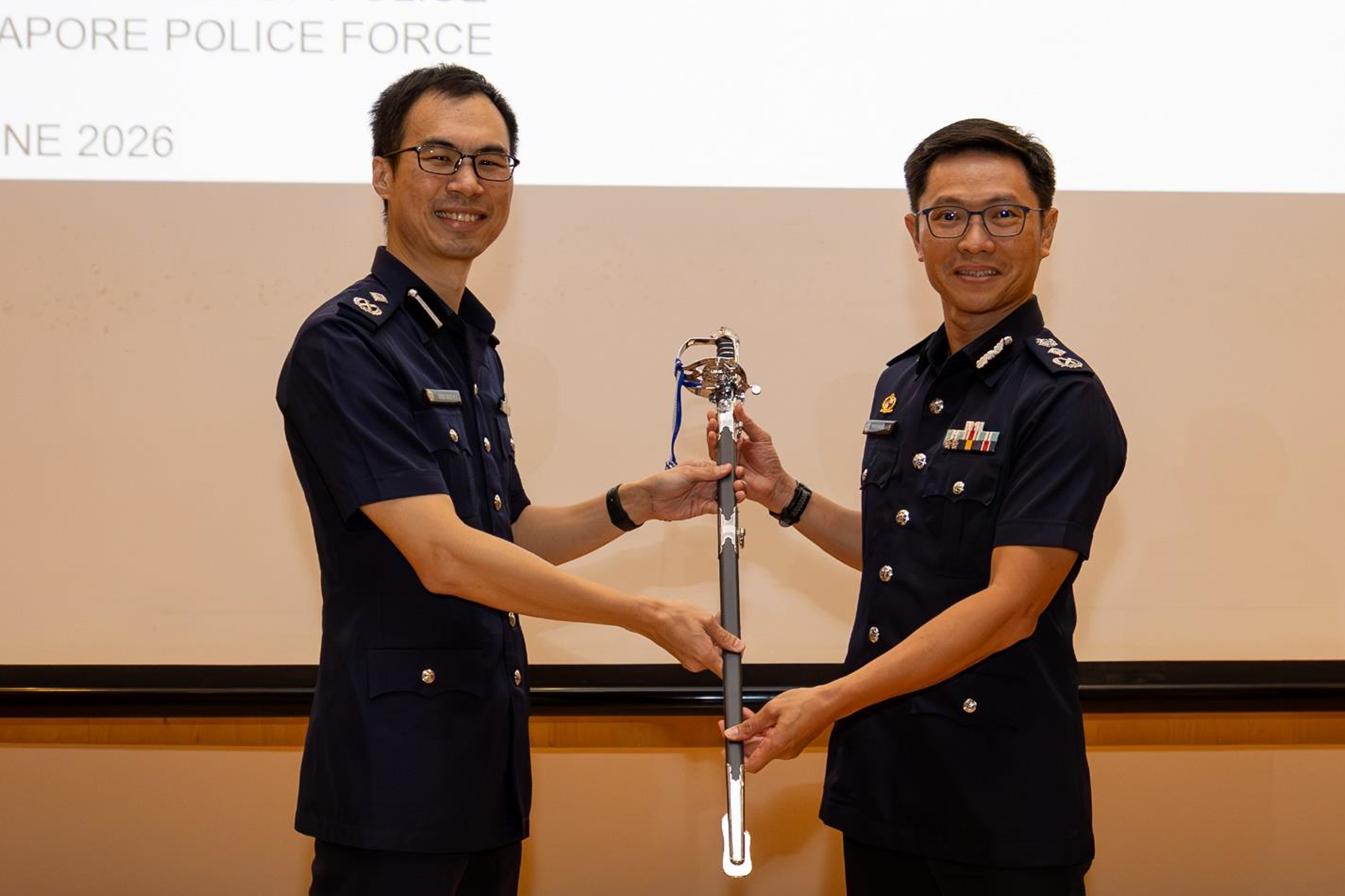 AC Wong Keng Hoe (left) handing over the command sword to CP How Kwang Hwee during the change of command ceremony.