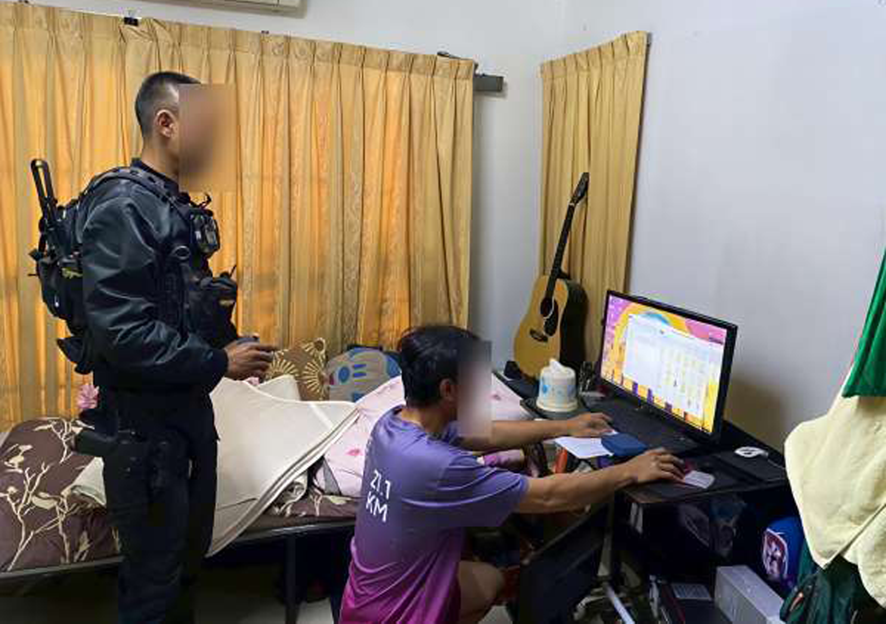 A Royal Thai Police officer standing over a suspect during the cross-border operation in Thailand.