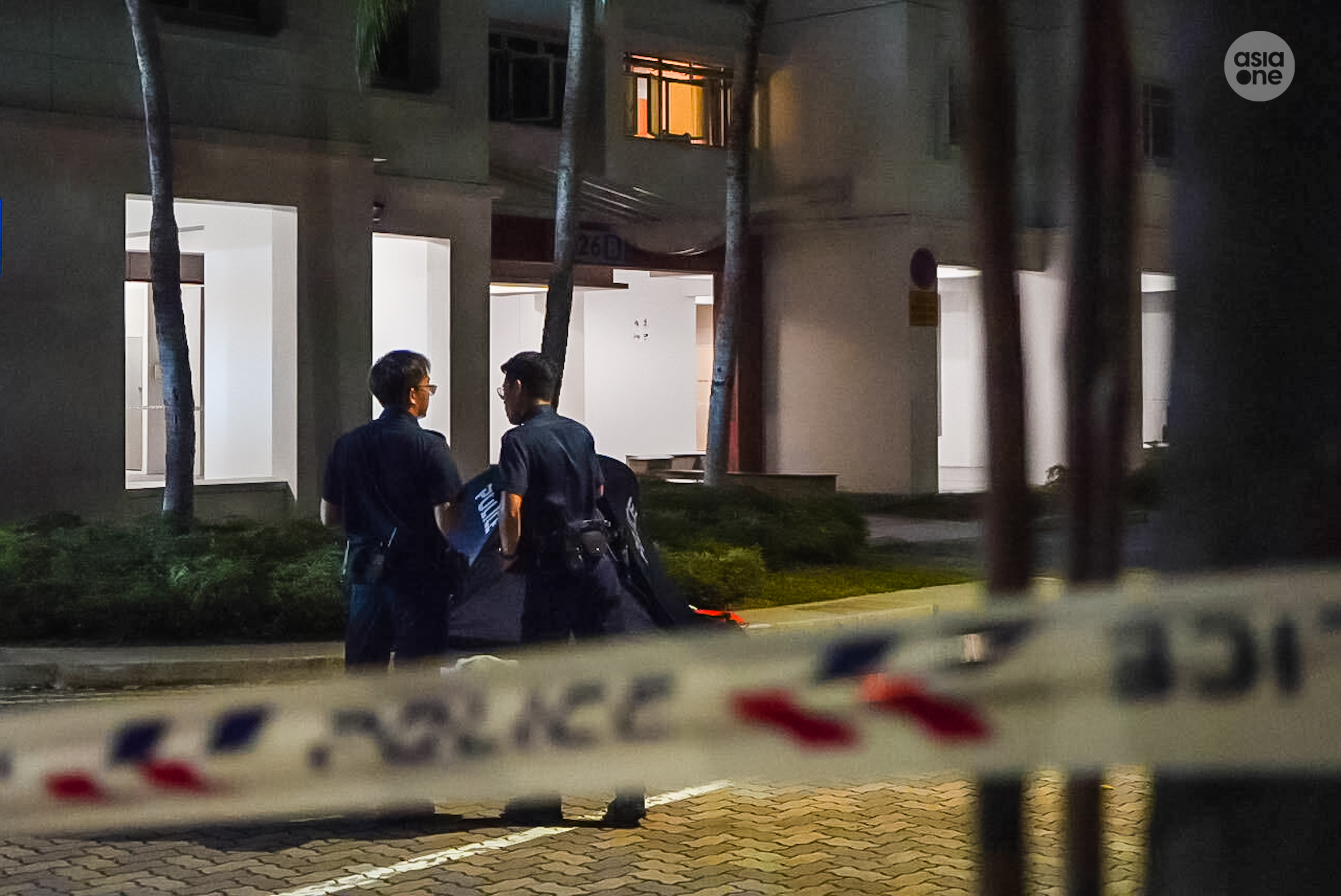 Police officers keeping watch within the cordoned off area as investigators conduct their investigations.