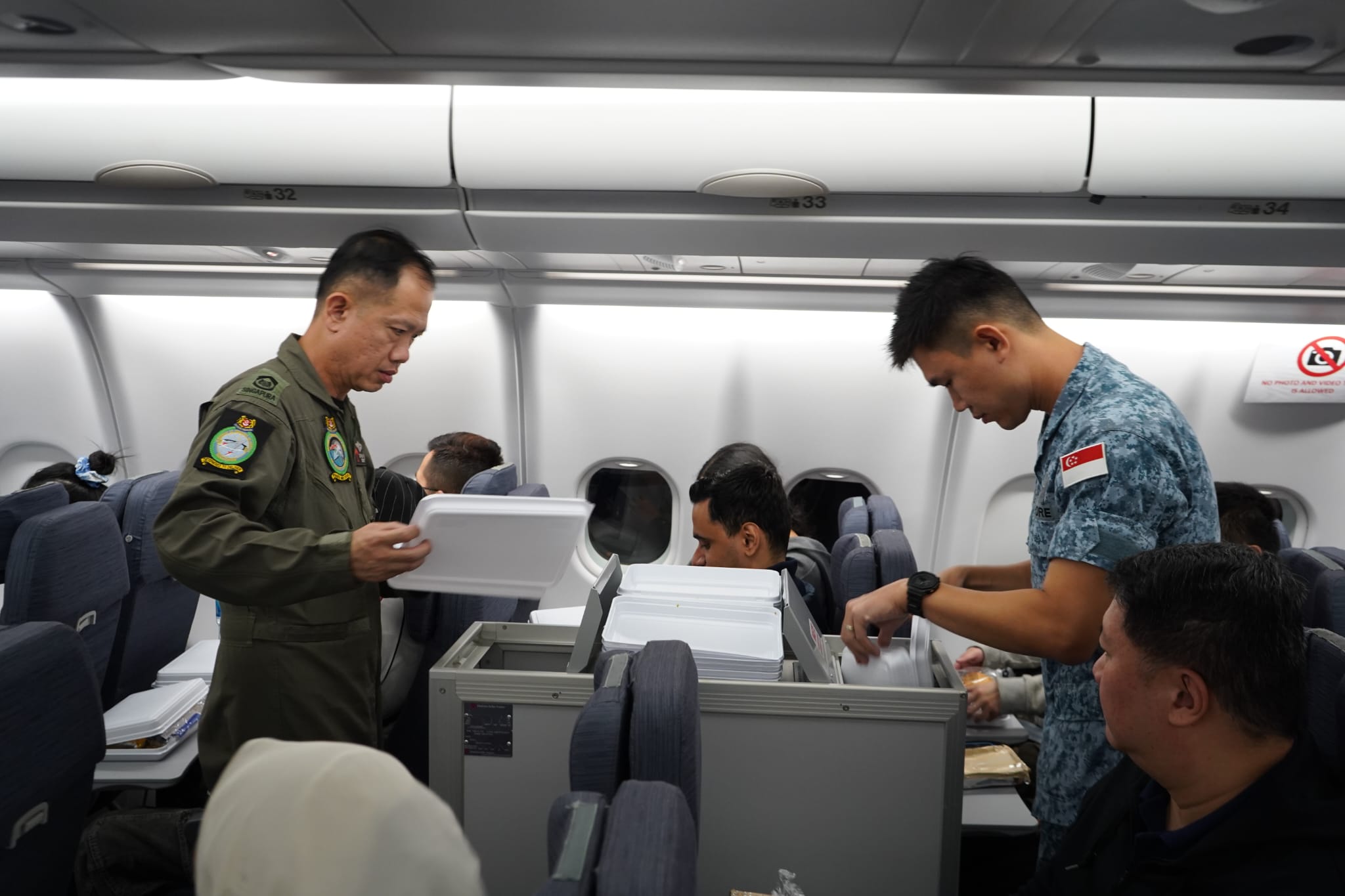 RSAF personnel serving their Singaporean passengers meals during the return flight to Singapore.