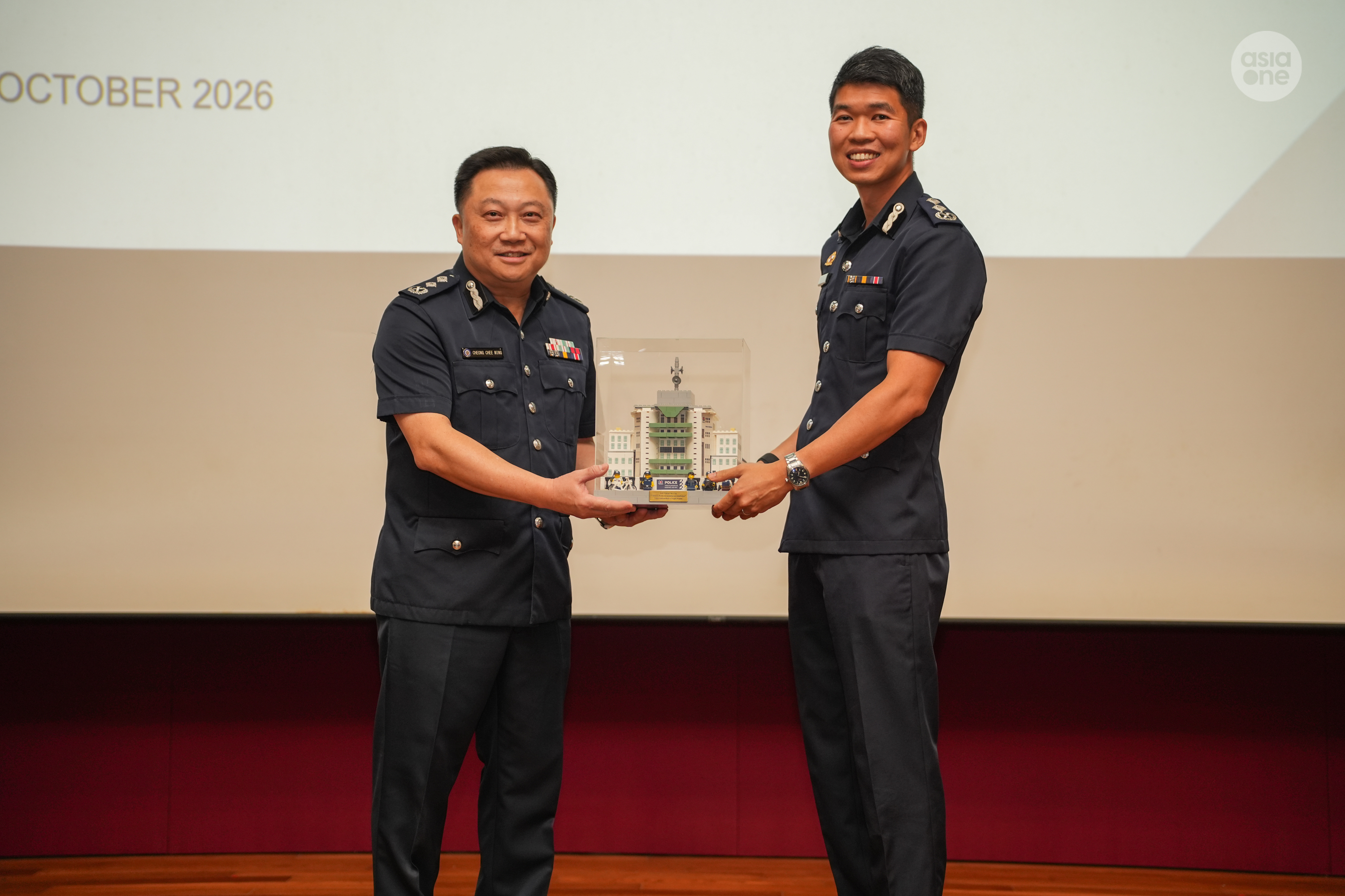 SAC Lee presenting SAC Cheong with a memento, showing the Tanglin Police Division headquarters.