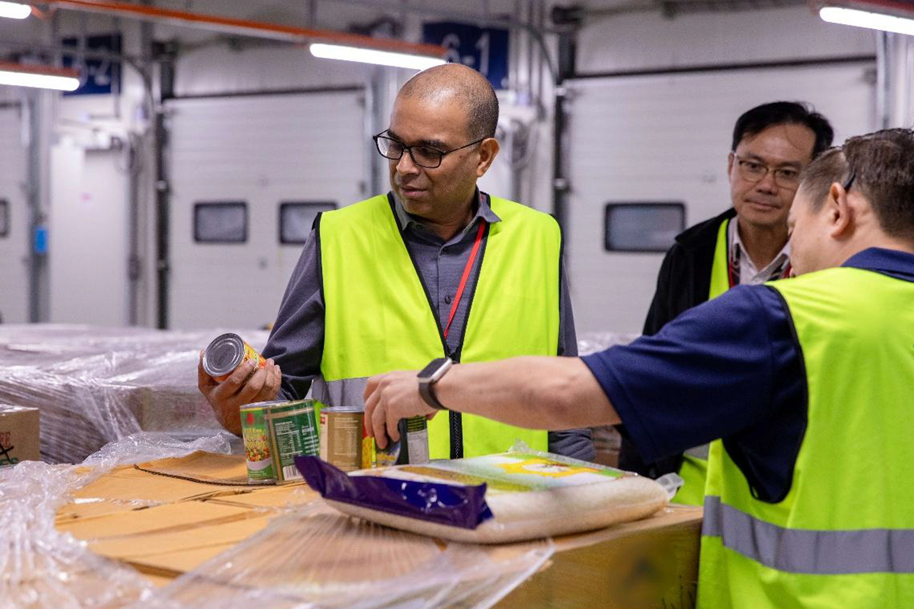 Senior Minister of State Janil Puthucheary inspecting food supplies due to be unpacked at the warehouse ahead of its distribution to a retail outlet.