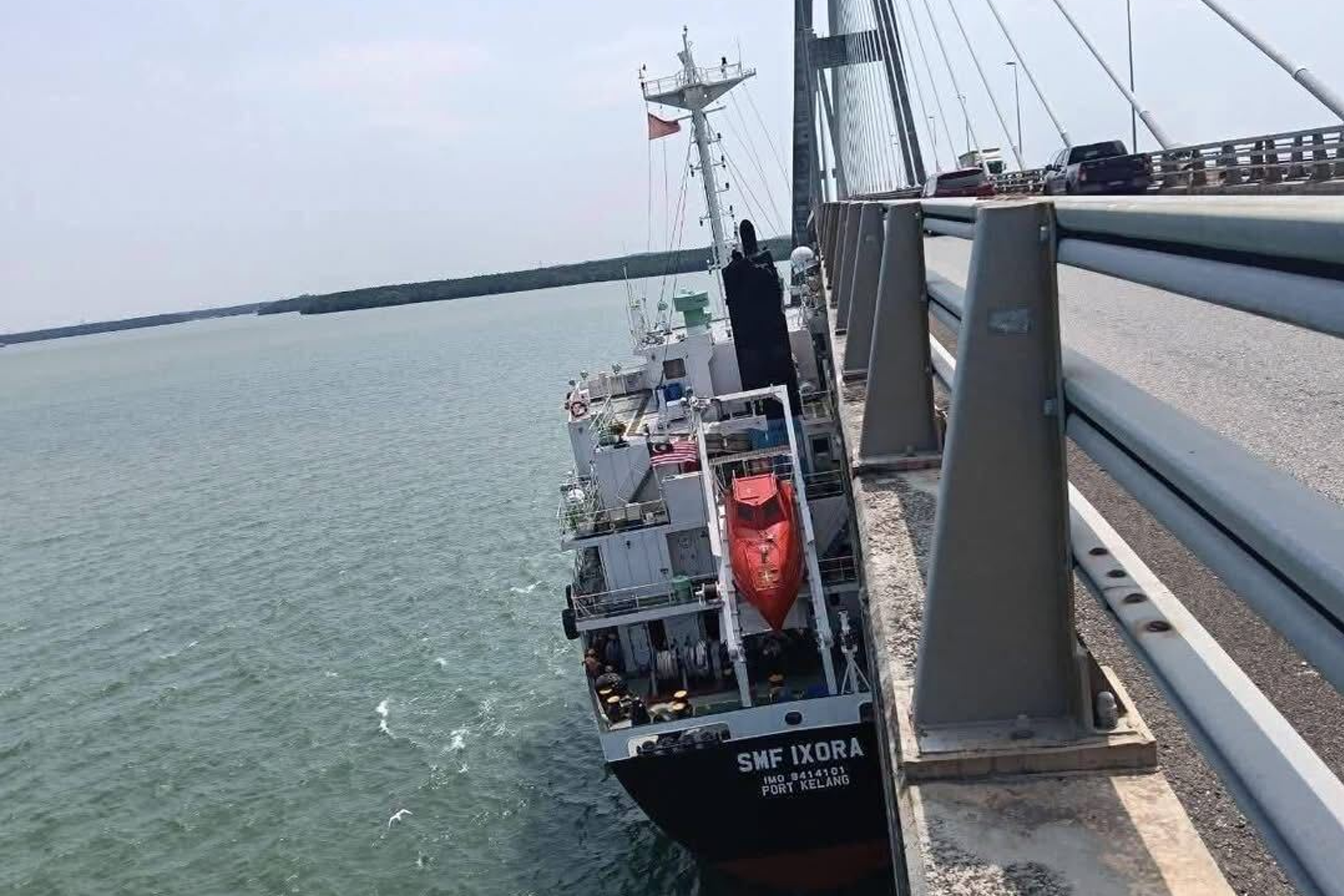 Malaysia-registered tanker SMF Ixora is seen alongside the Sungai Johor Bridge after hitting it.