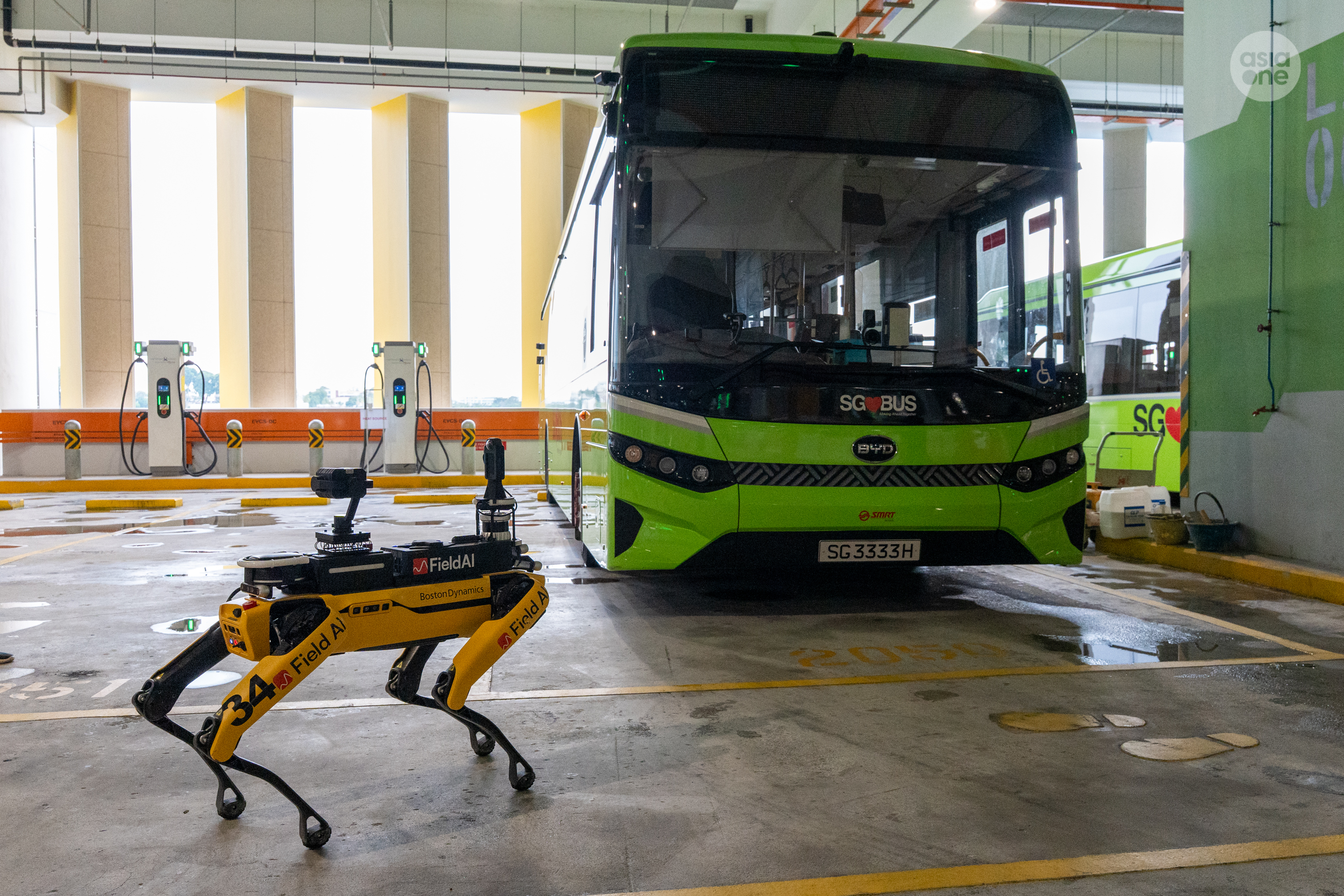 SMRT's autonomous surveillance robot dog conducting its 'paw-trol' as an electric bus is being charged.