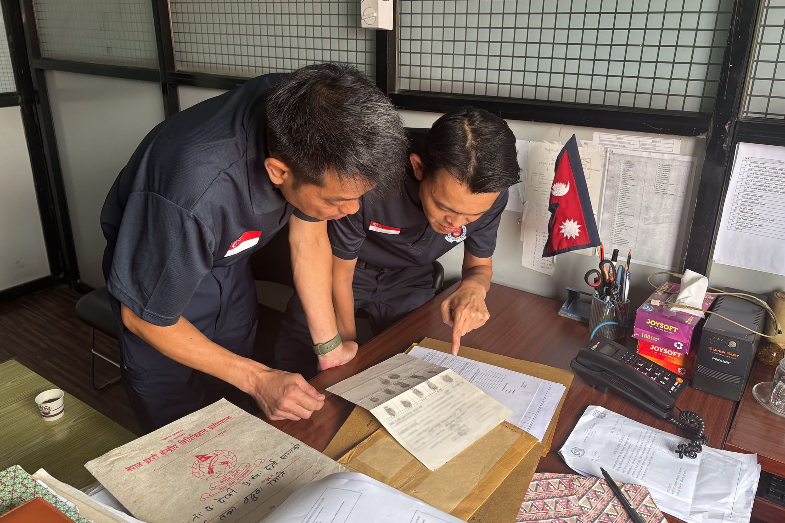 Two members from the Singapore contingent in Nepal examining fingerprint records.