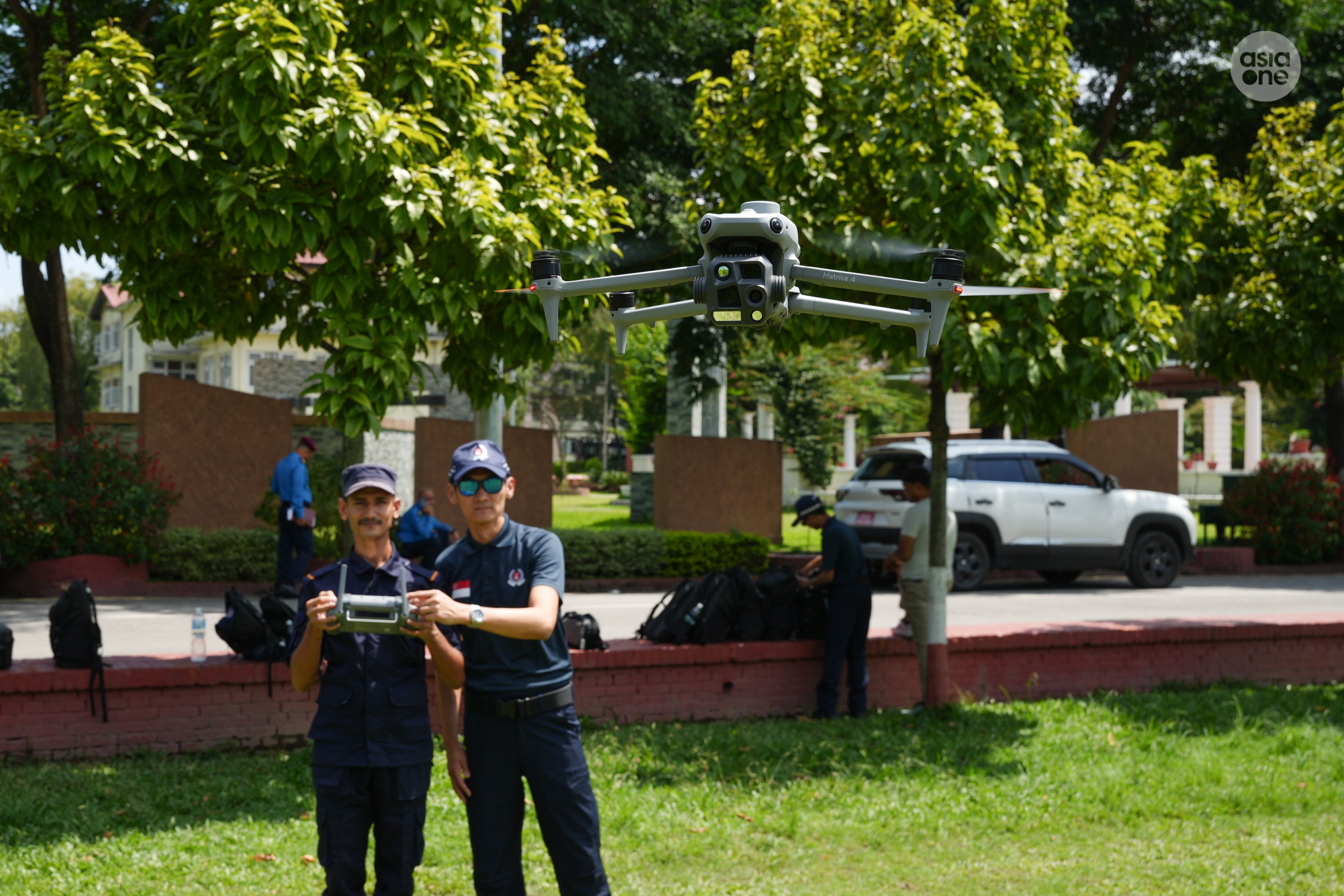 A Nepali police officer operating a DJI Mavic-4 drone towards AsiaOne photojournalist Rauf Khan as SUPT Sum Tuck Meng watches on.