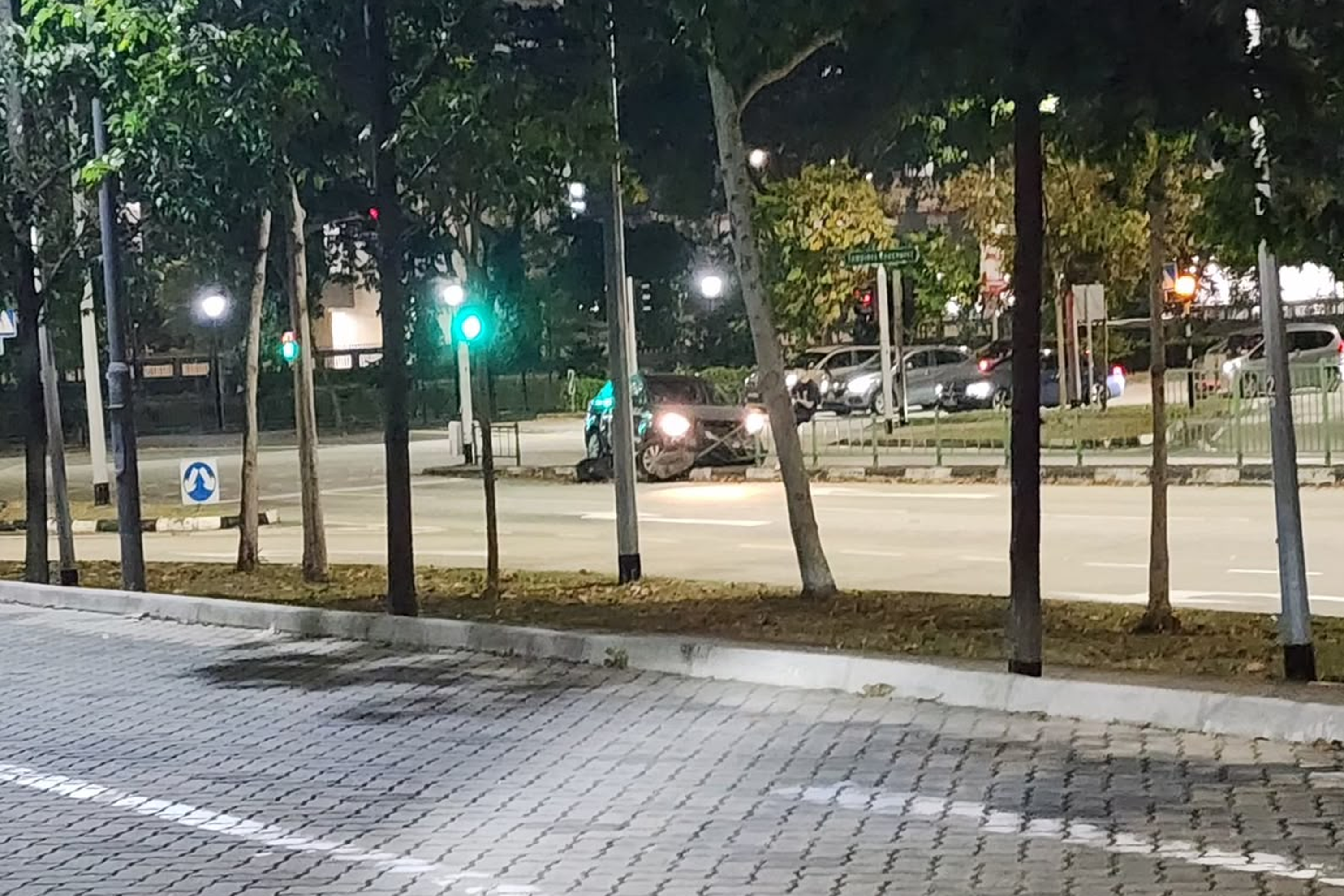 The visibly damaged GetGo car is seen stopped on the road divider along Tampines Course.