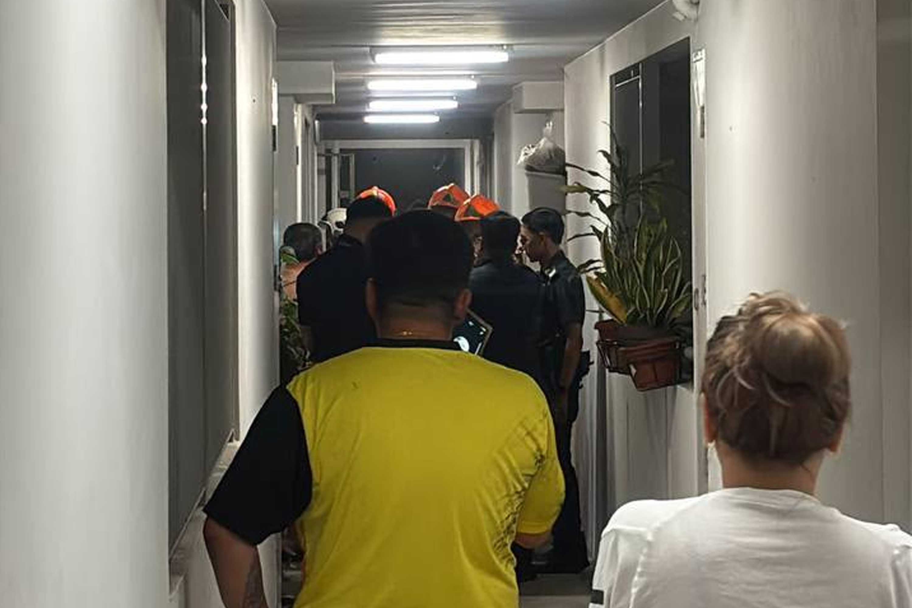 Firefighters and police officers outside the affected unit with the homeowner and residents who stepped in to help put out the fire.