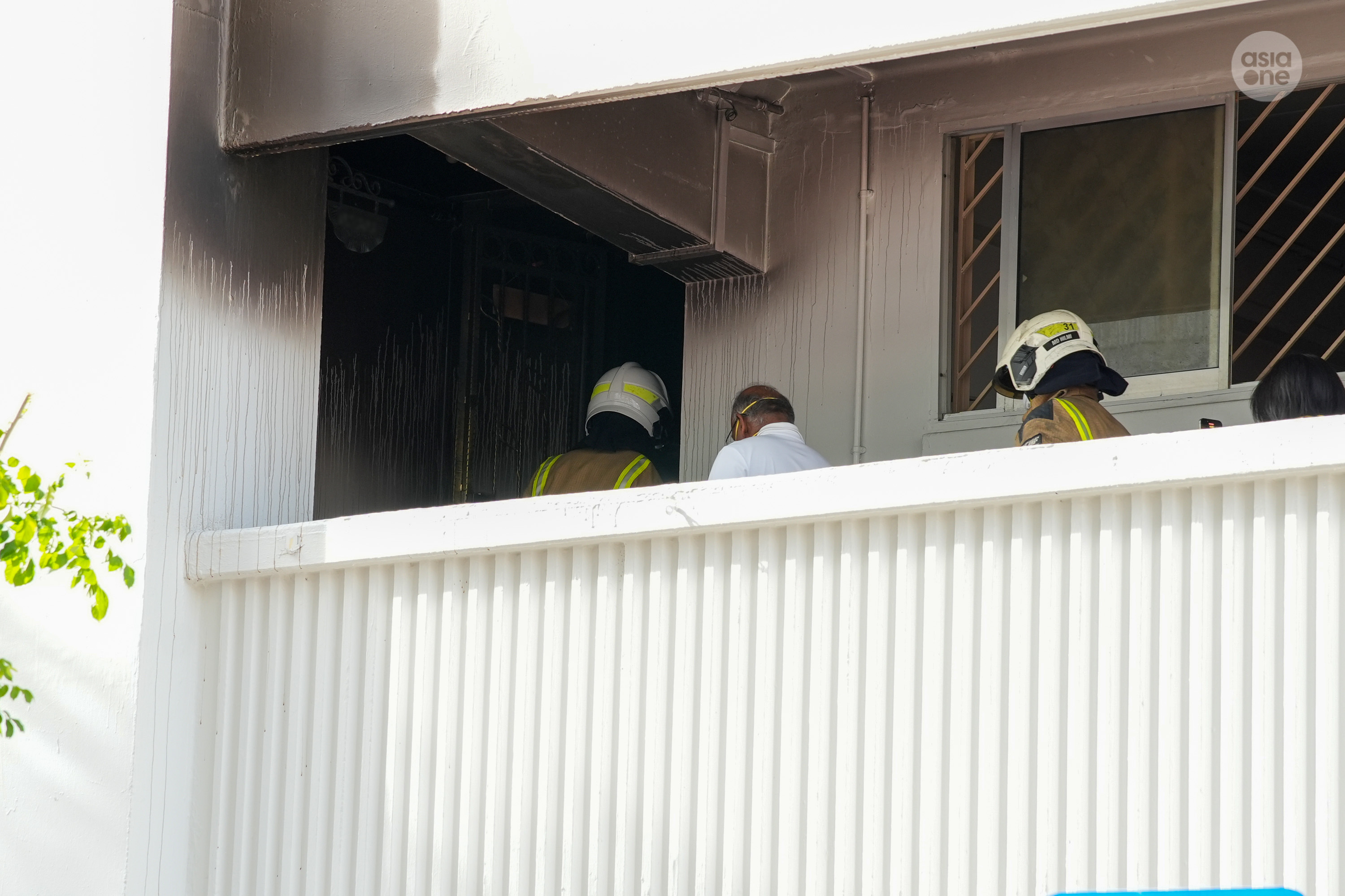 Coordinating Minister for National Security K Shanmugam is seen entering the affected unit after he spoke to the flat's occupiers. He was accompanied by SCDF firefighters.
