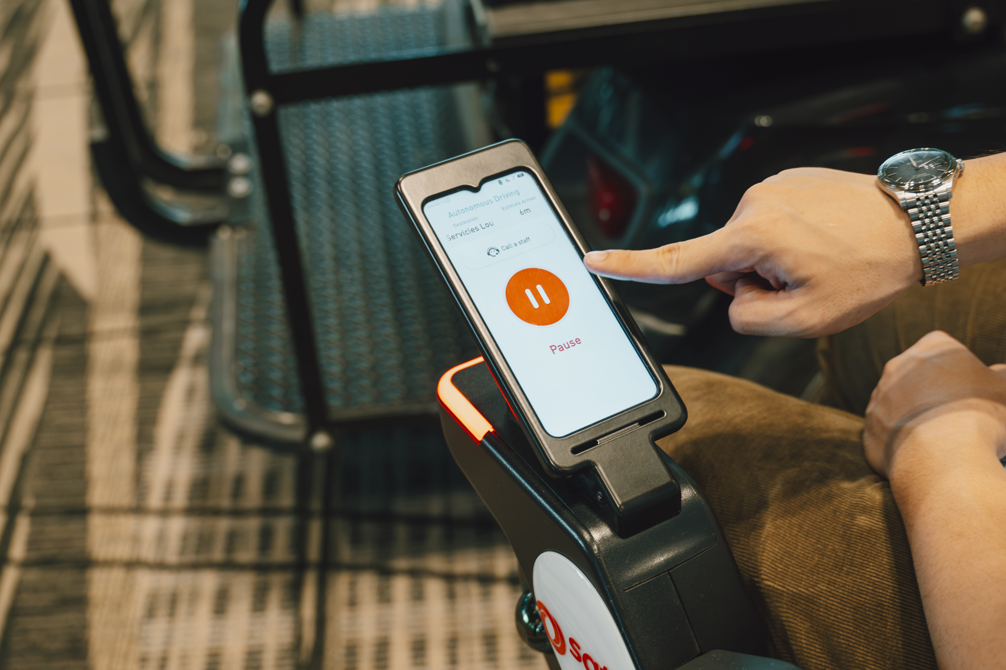 The autonomous wheelchair is equipped with safety features including a seatbelt (top) and a control panel to request assistance, if needed (bottom)