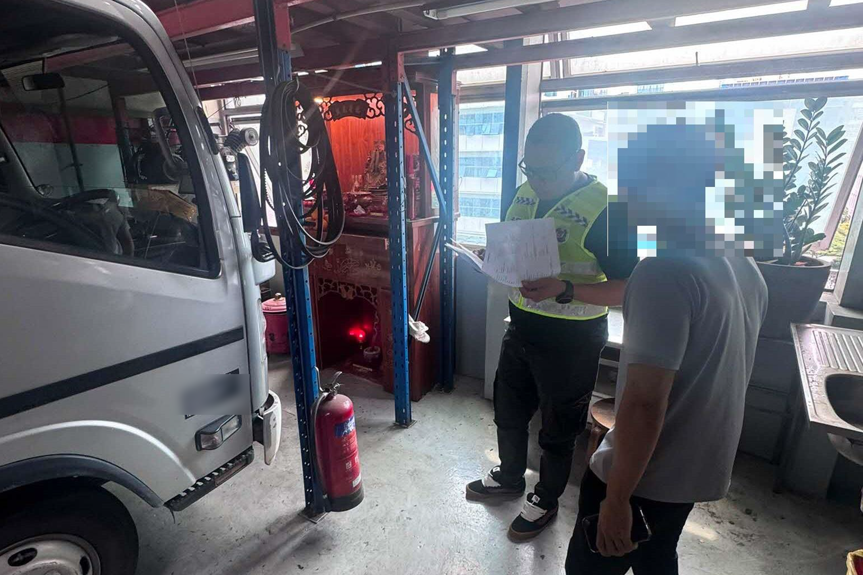 A traffic police officer reviewing speed limiter installation documents at a company premise during the two-day enforcement blitz.