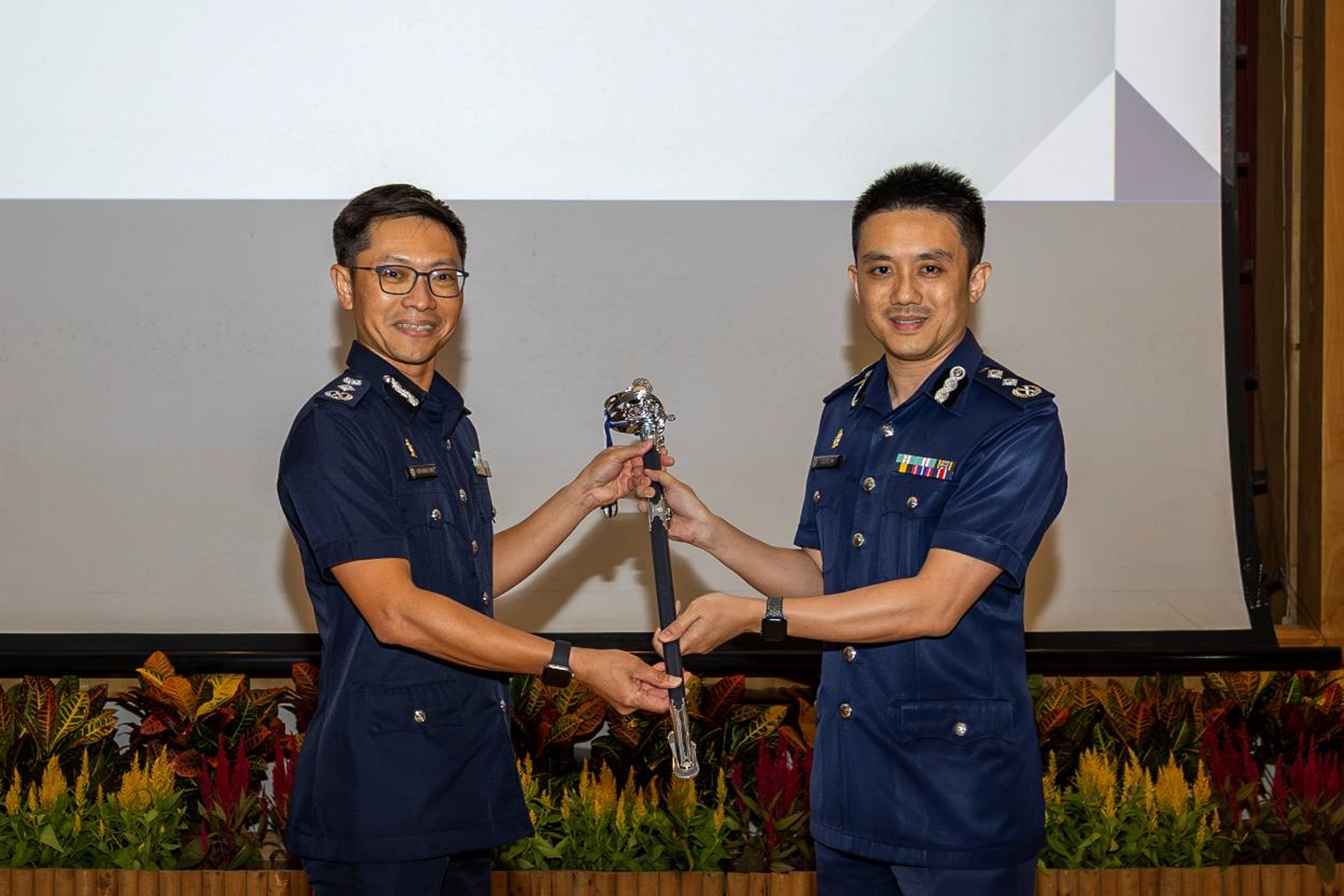 SAC Julius Lim (right) taking over the command sword from Commissioner of Police (CP) How Kwang Hwee during the change of command ceremony on July 13.