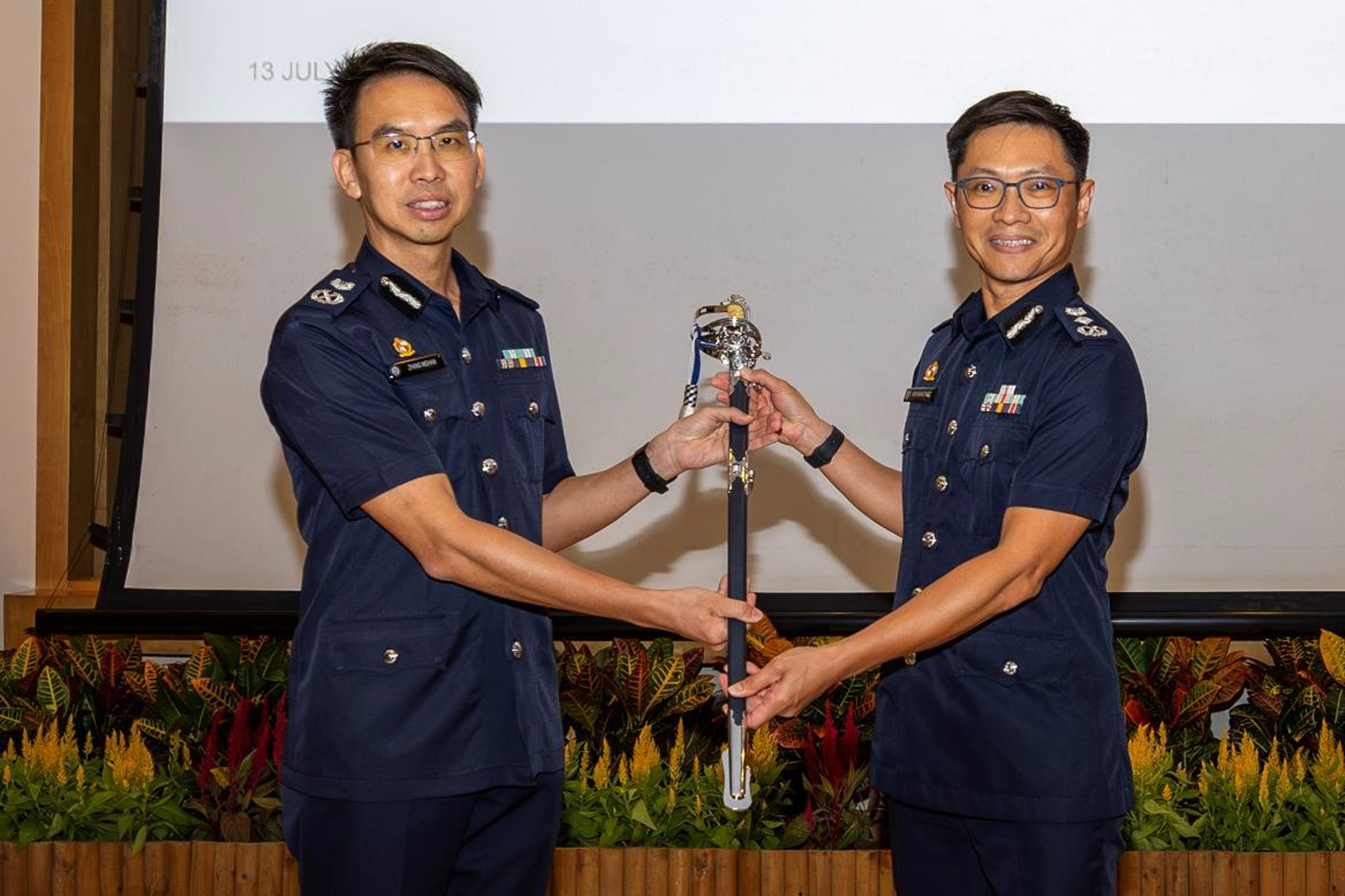 DCP Zhang Weihan (left) handing over the command sword to CP How Kwang Hwee during the change of command ceremony.