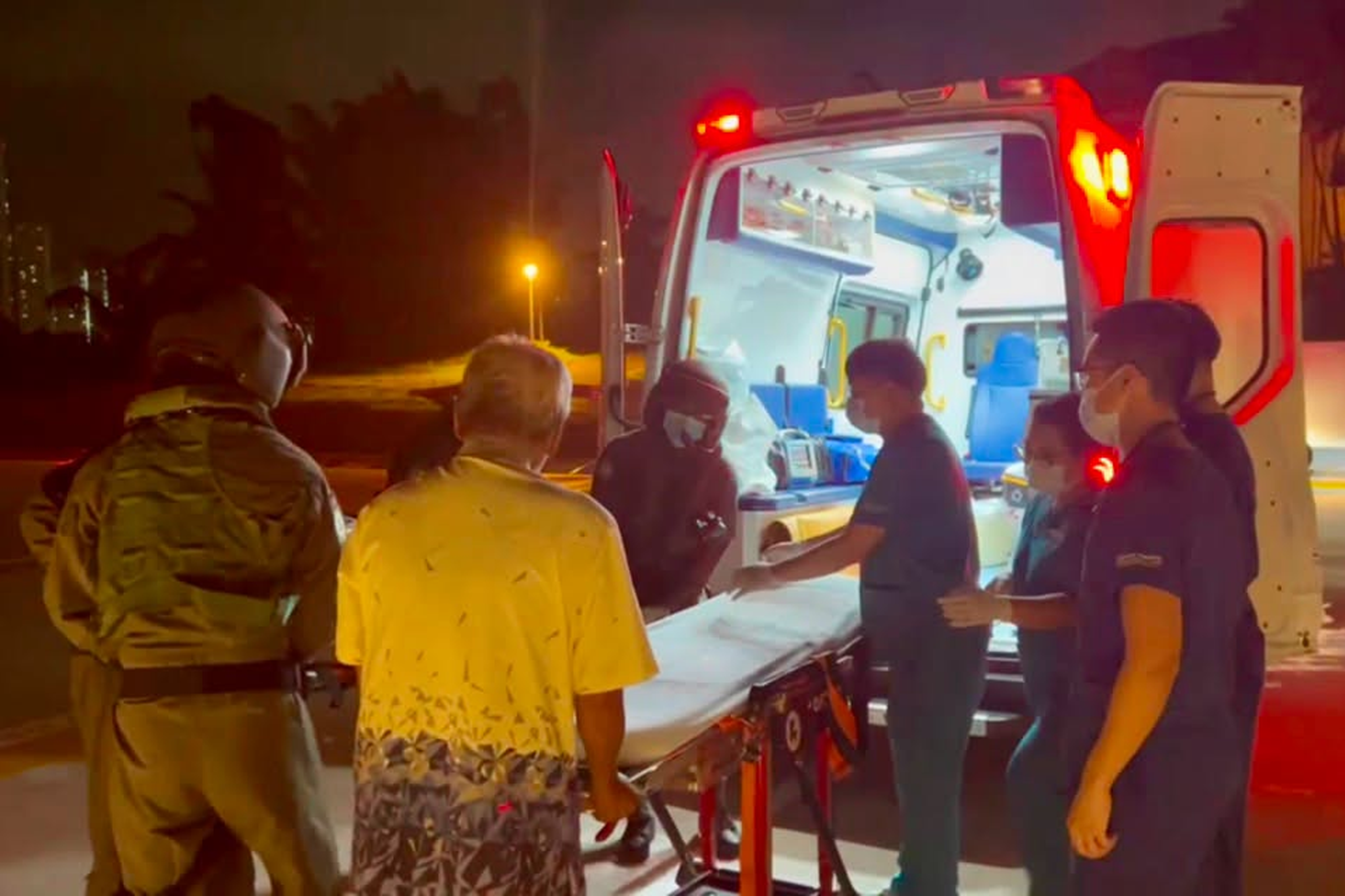 RSAF Rescue 10 medical personnel handing over the male patient to SGH healthcare workers.