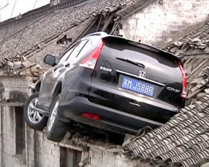 Car crashes into roof after driver accidentally steps on accelerator