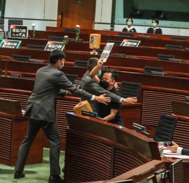 Hong Kong passes national anthem law as opposition lawmaker releases foul-smelling liquid in chamber