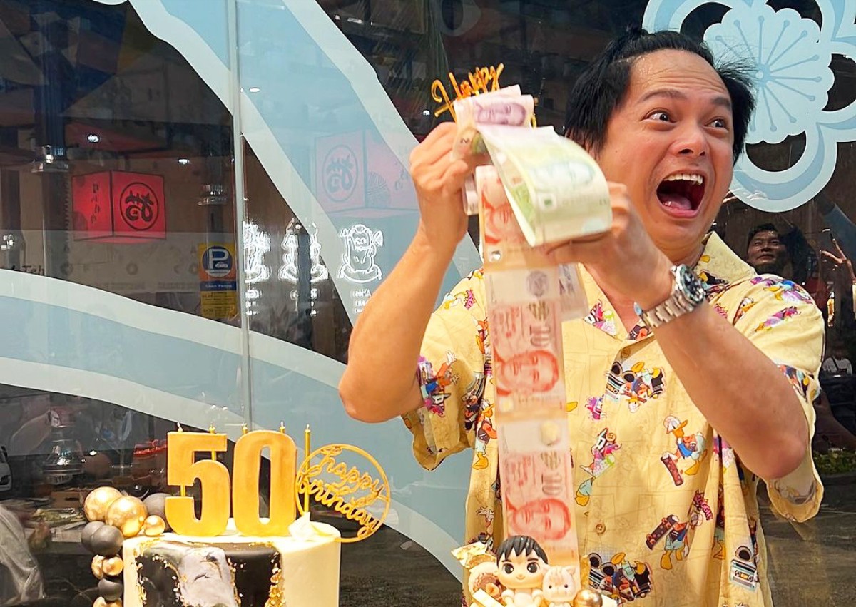 Dennis Chew receives money-pulling cake from Mark Lee for 50th birthday