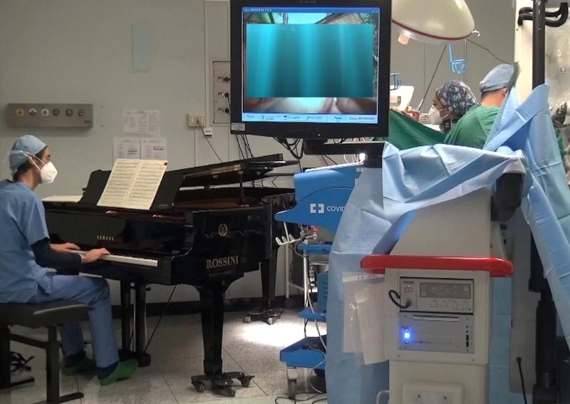 Therapeutic effect: Musical medic plays to cancer patient, 10, during surgery