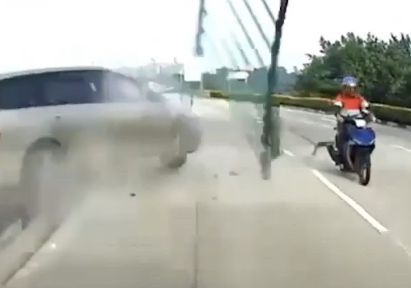 Internet marvels at motorcyclist's sheer luck after he escapes car crash and flying railing