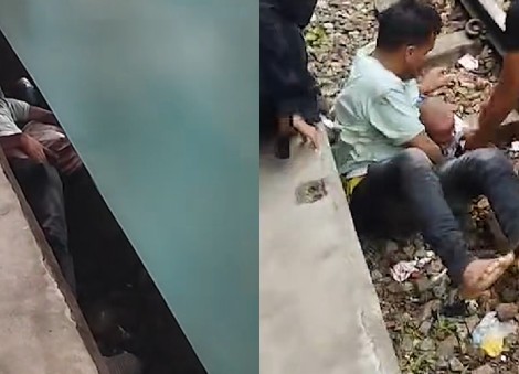 Bangladeshi father shields infant son on tracks as train passes overhead