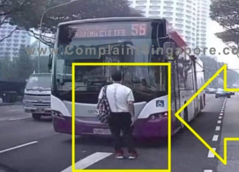 Man stands in middle of road, blocking bus in Bras Basah